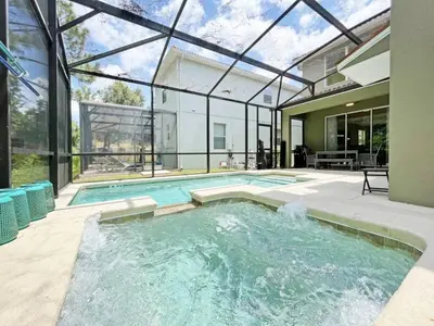 a swimming pool in a house with a glass ceiling at Banana Palm Paradise home in Kissimmee