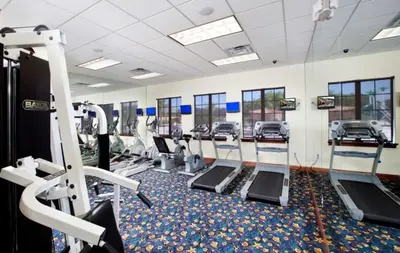 a gym with rows of treadmills and machines at Banana Palm Paradise home in Kissimmee