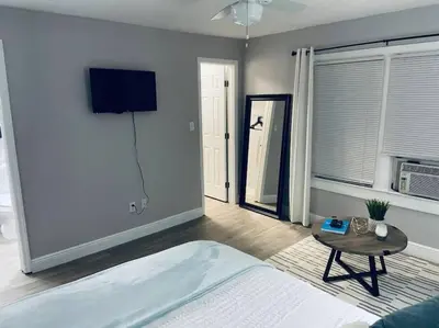 a bedroom with a bed and a table and a tv at 1 BD Apt close to Disney/Universal/Shopping/Dining in Kissimmee