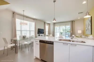 a kitchen with a sink and a table with chairs at Luxury Retreat with Pool in Orlando
