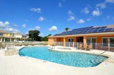 a house with a swimming pool with solar panels on it at Luxury Retreat with Pool in Orlando