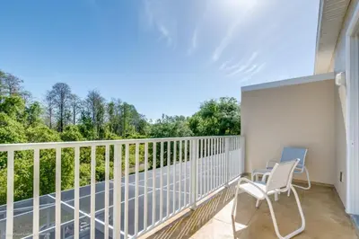 a balcony with two chairs and a view of trees at Luxury Retreat with Pool in Orlando