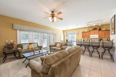 a living room with a couch and a table at Enchanted Villa Oasis in Orlando