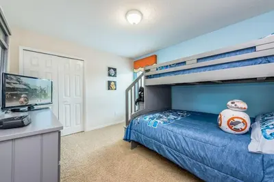 a bedroom with a bunk bed and a desk at Enchanted Villa Oasis in Orlando