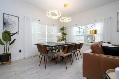 a dining room with a table and chairs and a couch at Luxury 5BR Storey Lake Retreat Near Disney 2969 in Kissimmee