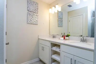 a bathroom with two sinks and a mirror at 3BR Resort Condo FREE Waterpark 3150 in Kissimmee
