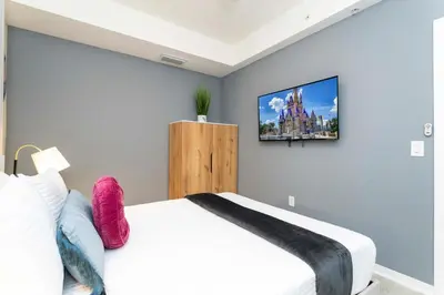 a bedroom with a bed and a tv on the wall at 3BR Resort Condo FREE Waterpark 3150 in Kissimmee