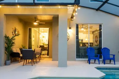 a patio with blue chairs and a swimming pool at Luxury 4Bed Near Disney, FreeVIP Resort 4335 in Kissimmee