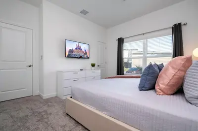 a white bedroom with a bed and a window at Stylish home Near Disney Free Waterpark 4407 in Kissimmee