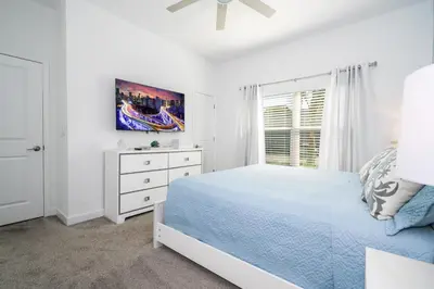 a white bedroom with a bed and a window at Cozy home Near Disney Free resort Access 4463 in Kissimmee