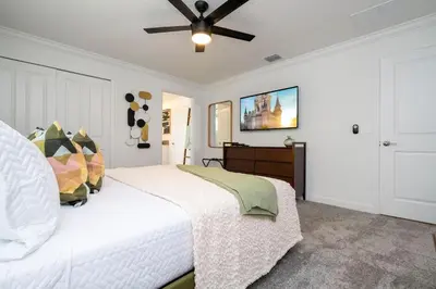 a bedroom with a white bed and a ceiling fan at Pro decor Disney Resort style FREE Waterpark 4467 in Kissimmee