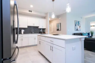 a kitchen with white cabinets and a black refrigerator at Resort Condo Near Disney FREE Waterpark 4721 in Kissimmee