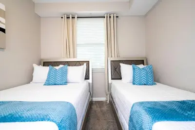 two beds in a room with blue and white at Resort Condo Near Disney FREE Waterpark 4721 in Kissimmee