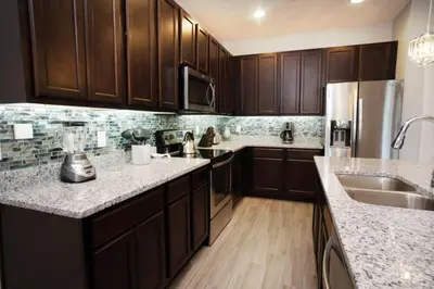 a kitchen with wooden cabinets and marble counter tops at Gorgeous Vacation Home near Everywhere in Kissimmee