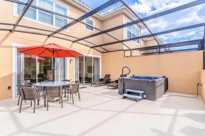 a patio with a table and chairs and a grill at Private Spa Townhome at Regal Oaks Resort in Orlando