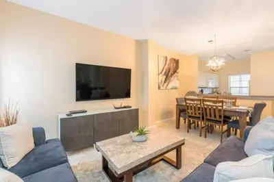 a living room with a couch and a dining room at Townhome at Emerald Island Resort in Kissimmee