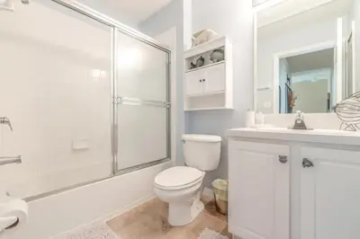 a white bathroom with a toilet and a shower at Townhome at Emerald Island Resort in Kissimmee