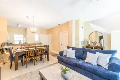 a living room with a blue couch and a dining room at Townhome at Emerald Island Resort in Kissimmee