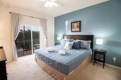 a bedroom with a large bed with blue walls at Townhome at Oakwater Resort in Orlando
