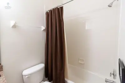 a bathroom with a toilet and a shower with a shower curtain at Townhome at Oakwater Resort in Orlando