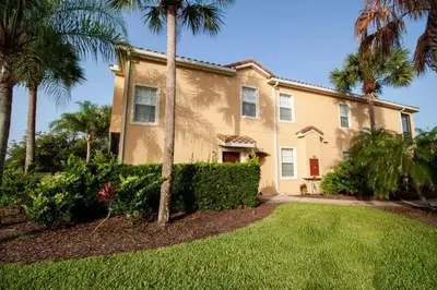 a house with palm trees in front of a yard at Townhome at Oakwater Resort in Orlando