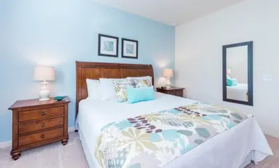 a bedroom with a bed and a dresser and a mirror at Townhome at West Lucaya Resort 3212 in Orlando