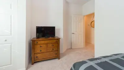 a bedroom with a tv on a wooden dresser at Townhome at West Lucaya Resort 3212 in Orlando