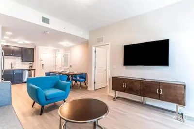 a living room with a blue chair and a tv at Apartment at Vista Cay Resort in Orlando