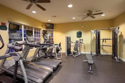 a gym with several treadmills and cardio machines at Apartment at Vista Cay Resort in Orlando