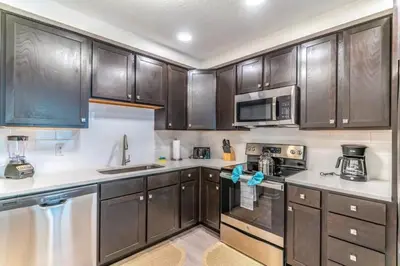 a kitchen with dark wooden cabinets and appliances at Apartment at Vista Cay Resort in Orlando