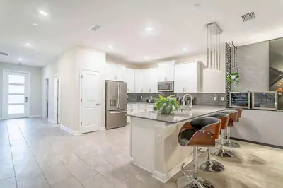 a large kitchen with white cabinets and stainless steel appliances at Private Pool and Spa Home at Storey Lake Resort in Kissimmee