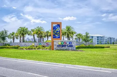 a sign in the grass next to a street at Private Pool and Spa Home at Storey Lake Resort in Kissimmee