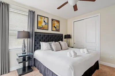 a bedroom with a large bed with a black headboard at 11 bd home Movie Room Close to Disney Sleeps 24 in Orlando