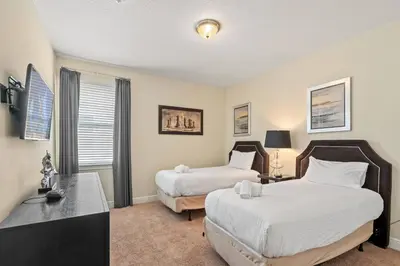 a bedroom with two beds and a desk at 11 bd home Movie Room Close to Disney Sleeps 24 in Orlando