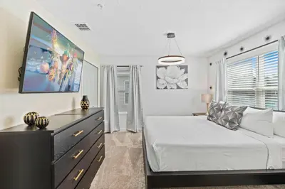a bedroom with a large white bed and a dresser at 2452 Reading Trail in Kissimmee