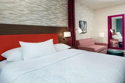 a hotel room with a large bed and a chair at Home2 Suites By Hilton Lake Mary Orlando in Lake Mary