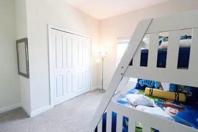 a white bedroom with a bunk bed and a white door at Private Pool Townhome at Storey Lake Resort in Kissimmee
