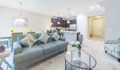 a living room with a blue couch and a kitchen at Townhome at Compass Bay Community in Kissimmee