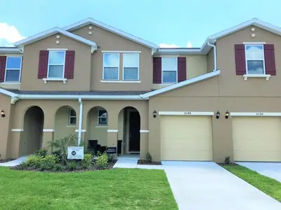 a large house with a garage at Townhome at Compass Bay Community in Kissimmee