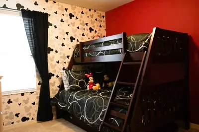 a black bunk bed in a bedroom with a red wall at Townhome at Compass Bay Community in Kissimmee