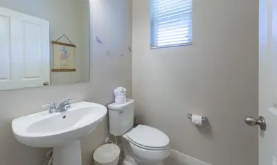 a white bathroom with a toilet and a sink at Townhome at Compass Bay Community in Kissimmee