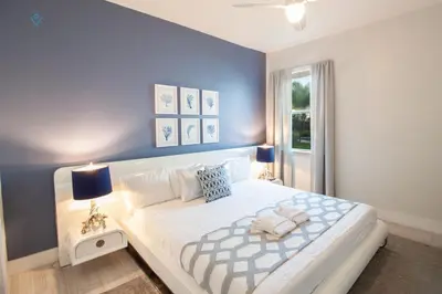 a bedroom with a large white bed with blue walls at Private Pool and Spa Home at Encore Resort at Reunion in Orlando