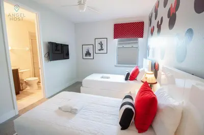 a bedroom with a white bed with red pillows at Private Pool and Spa Home at Encore Resort at Reunion in Orlando