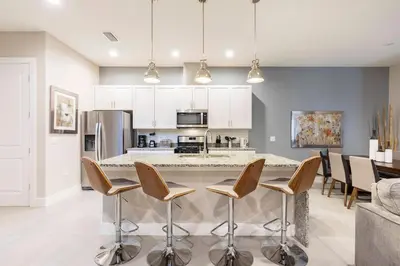 a kitchen with a large island with bar stools at GORGEOUS 5 Suites Villa at Summerville Resort in Orlando