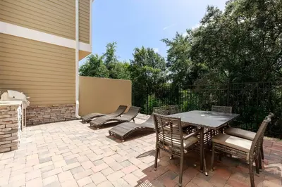 a patio with a table and chairs on a brick patio at GORGEOUS 5 Suites Villa at Summerville Resort in Orlando