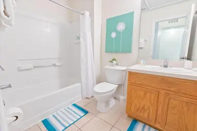 a bathroom with a toilet and a tub and a sink at 8536 Crystal Cove in Kissimmee