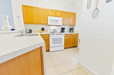 a kitchen with wooden cabinets and a white stove top oven at 8536 Crystal Cove in Kissimmee