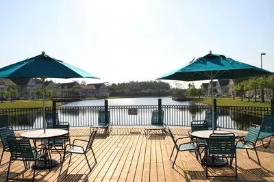 a deck with tables and chairs and umbrellas at Orlando House in Kissimmee