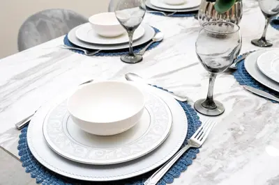 a table with white plates and silverware on a table at Amazing 3BedroomsNear to DisneyThemed rooms in Kissimmee