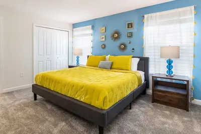 a bedroom with a bed with a yellow bedspread at Beautiful house great location private pool in Kissimmee